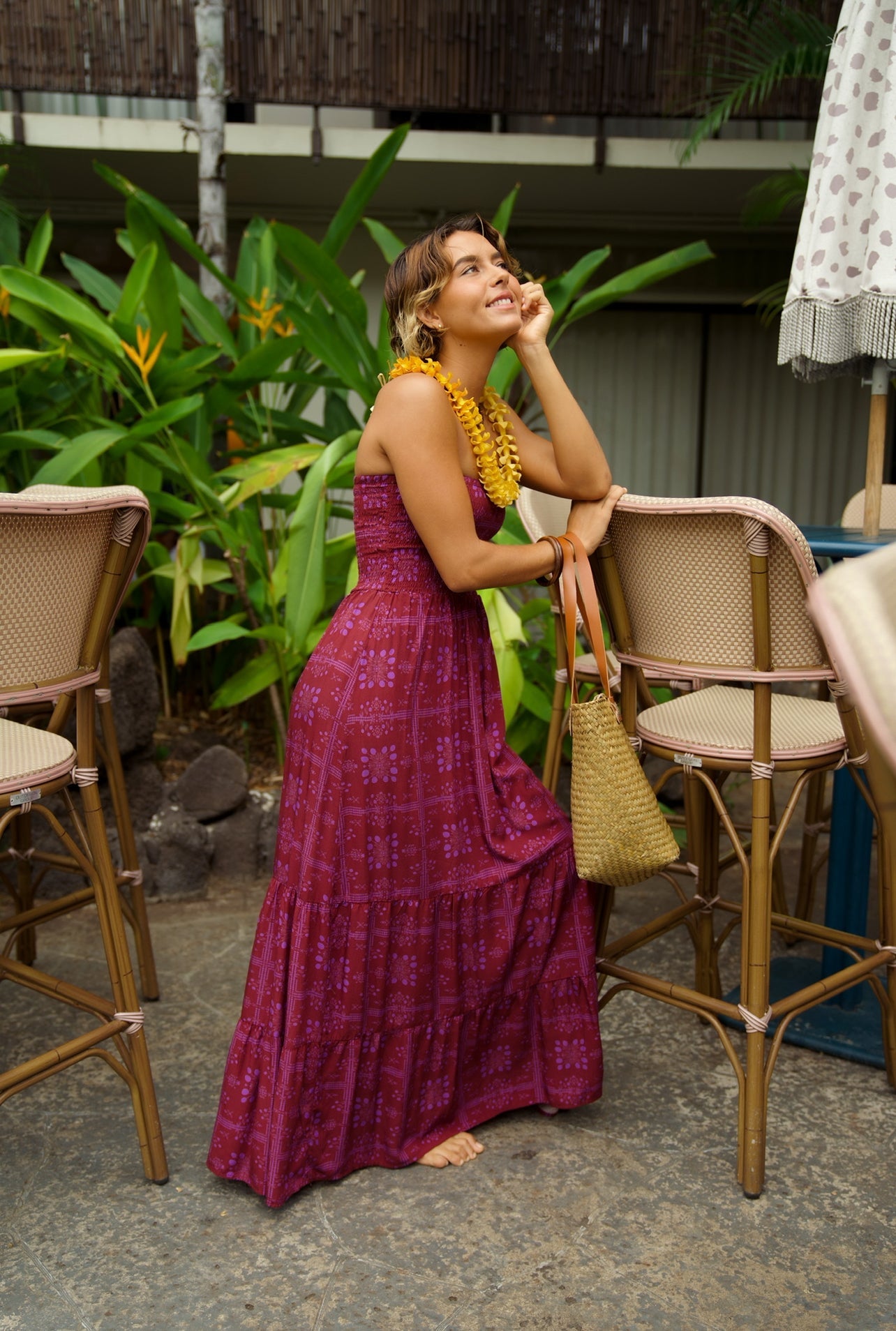 EHA Culture Mango Sunset Maile Dress displayed on a hanger, showcasing vibrant colors and flowing fabric in a full-length view.