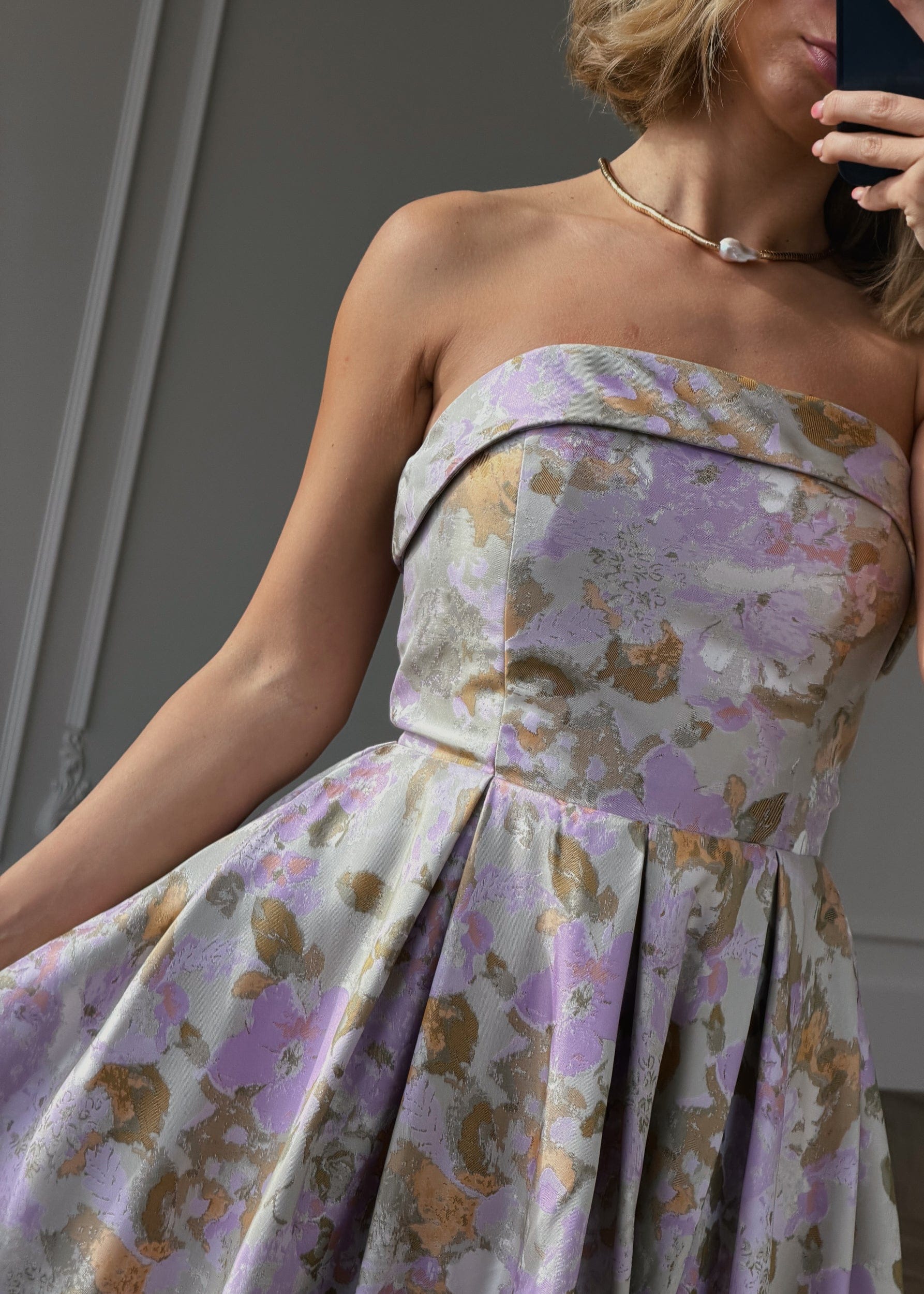 JessaKae Anastelle strapless jacquard dress with intricate pattern, fitted bodice, and flowing skirt, displayed on a hanger.