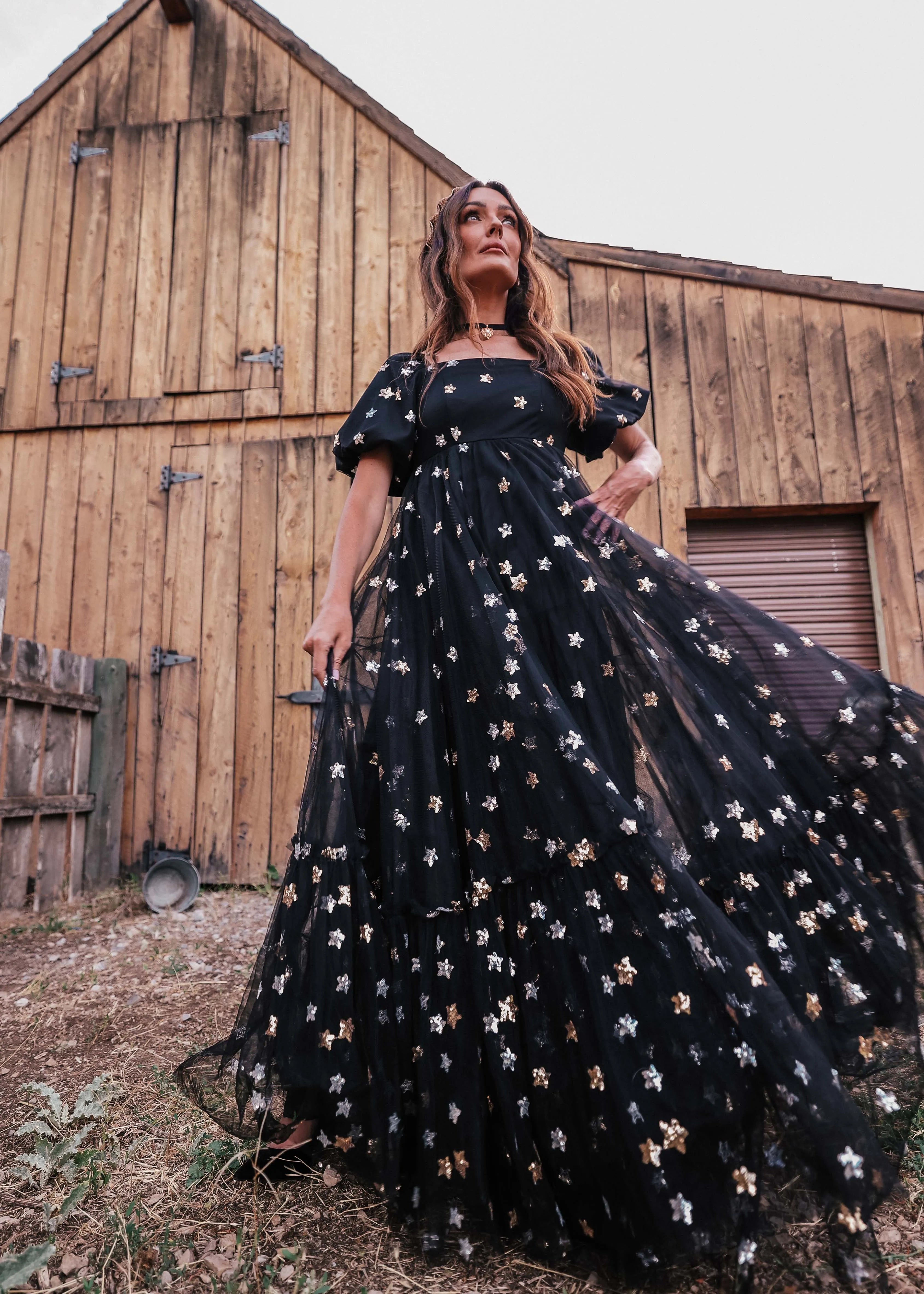 Black Wendy Dress by JessaKae featuring a star pattern, fitted bodice, and flowy skirt, displayed on a mannequin.